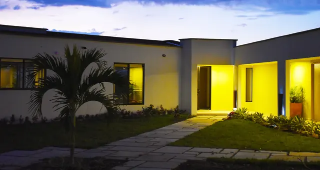 La casa del hotel al anochecer, con las luces de la entrada encendidas